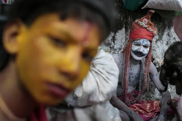 A Bangladeshi Hindu devotee dressed as Hindu God Shiva sits on the banks of the Brahmaputra river during a Hindu bathing ritual in Langalbandh, 20 kilometers (12 miles) southeast of capital Dhaka, Bangladesh, Friday, March 27, 2015. Local police chief Nazrul Islam said a stampede took place in a Hindu pilgrimage spot on the banks of the Brahmaputra river during an annual religious bathing ritual. (Photo by A. M. Ahad/AP Photo)