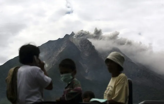 Mount Sinabung spews volcanic materials as villagers board a truck to flee their homes following its eruption in Karo, North Sumatra, Indonesia, Sunday, September 15, 2013. (Photo by Binsar Bakkara/AP Photo)