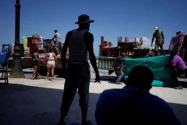 People load trucks with furniture to be relocated prior to the arrival of Storm Elsa, in Havana, Cuba, July 4, 2021. (Photo by Alexandre Meneghini/Reuters)