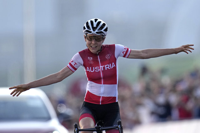 Anna Kiesenhofer of Austria, crosses the line solo to win the gold medal in the women's cycling road race at the 2020 Summer Olympics, Sunday, July 25, 2021, in Oyama, Japan. (Photo by Christophe Ena/AP Photo)