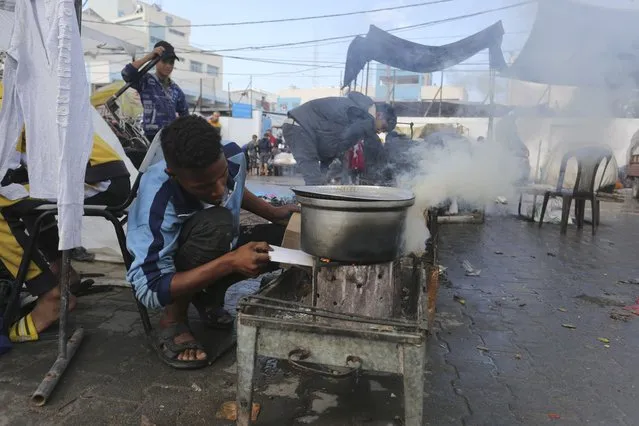 Palestinians cook at a square in Rafah, Gaza Strip, during the ongoing Israeli bombardment of the Gaza Strip on Tuesday, November 14, 2023. (Photo by Hatem Ali/AP Photo)