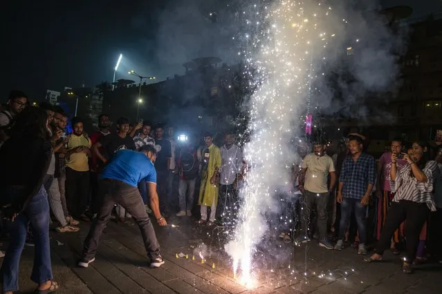 Indian cricket fans light crackers outside the Wankhade Stadium as they celebrate their team's victory in the ICC Cricket World Cup semi-final match against New Zealand in Mumbai, India, Wednesday, November 15, 2023. (Photo by Altaf Qadri/AP Photo)