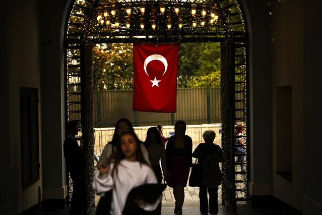 People pass under the Turkish Flag on Istiklal Street, Istanbul, Wednesday, October 25, 2023. Turkey is marking the 100th anniversary of the creation of the modern, secular Turkish Republic from the ruins of the Ottoman Empire on Sunday but without any grand pageantry or gala reception to memorialize the important milestone. (Photo by Emrah Gurel/AP Photo)