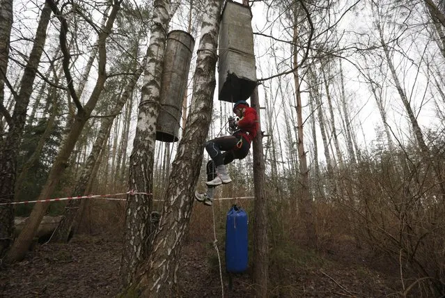 Belarusian cave explorer takes part in an competition of speleologists in the forest near village of Raubichi, on the outskirts of Minsk, Belarus, Saturday, April 4, 2015. These competitions are held each year to improve and demonstrate the skills needed for the study of caves. (Photo by Sergei Grits/AP Photo)
