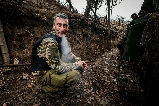 A Ukrainian serviceman of the 65th mechanized brigade smoke on position of a Soviet-made 2s1 Gvozdyka 120mm howitzer in the Zaporizhia region, Ukraine, 15 November 2023, amid the Russian invasion. Russian troops entered Ukrainian territory in February 2022, starting a conflict that has provoked destruction and a humanitarian crisis. (Photo by Kateryna Klochko/EPA)