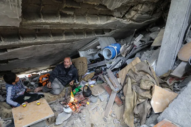 Palestinian Yassin Ahmed Al-Qara, 47 years old, sits with his family under the rubble of his house, which was destroyed by air strikes in the Khuza’a area on November 28, 2023 in Khan Yunis, Gaza. A temporary ceasefire between Israel and Hamas has held since Friday, offering Gaza residents respite from constant bombardment. The Hamas-run health ministry in Gaza says that over 14,500 people in Gaza have been killed since Oct. 7, when Israel launched a military offensive in retaliation for Hamas's deadly cross-border attacks. (Footage by Ahmad Hasaballah/Getty Images)
