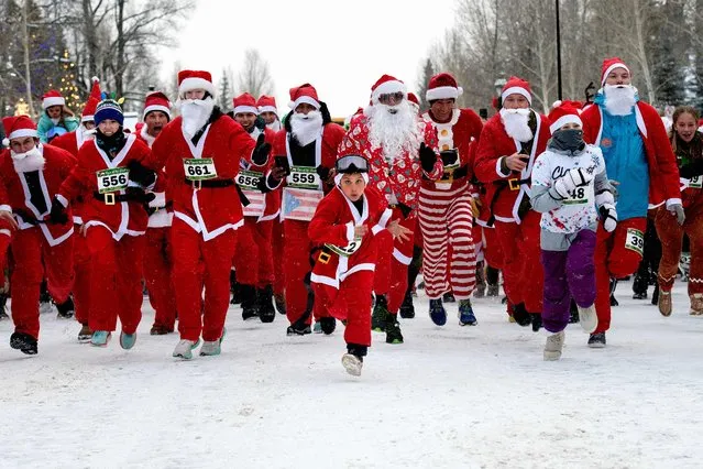 Runners dressed in Santa Claus outfits take off from the starting line during the Race of the Santas in Breckenridge, Colorado, on December 2, 2023. (Photo by Jason Connolly/AFP Photo)