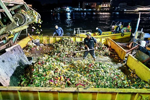 This photo taken on November 27, 2023 shows municipal workers collecting “Krathong” or floating baskets released into the Chao Phraya river marking the annual Loy Krathong festival celebrations, during a clean-up drive in Bangkok. The Loy Krathong festival, celebrated in Thailand by releasing decorative baskets into rivers and ponds, was given an environmentally sustainable twist in the Thai capital on November 27 as clean-up workers removed the floats from waterways and digital projections sought to replace the still-popular traditional physical offerings. (Photo by Manan Vatsyayana/AFP Photo)