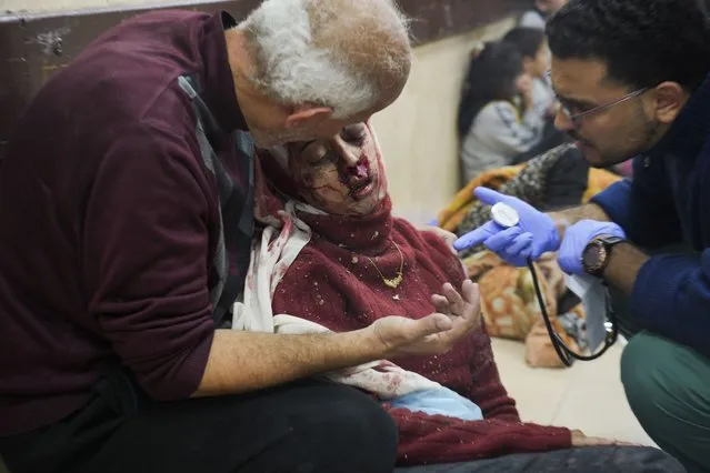 Palestinians wounded in Israeli bombardment are helped in a hospital in Deir al Balah, Monday, January 1, 2024. (Photo by Hatem Moussa/AP Photo)
