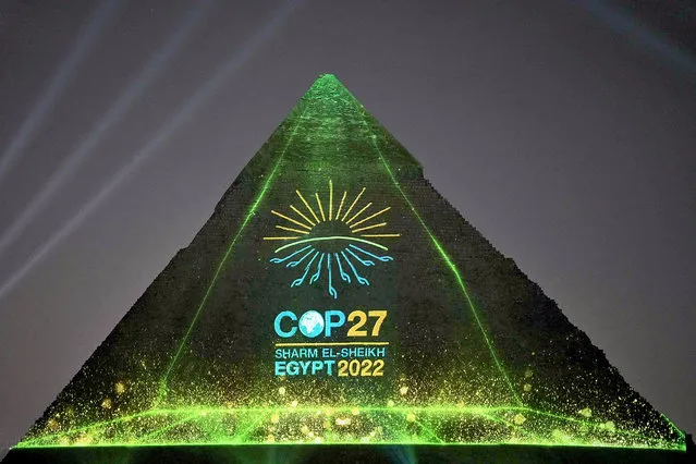 A handout picture released by the Egyptian Presidency of the 27th UN Climate Change Conference shows the illumination of Khafre Pyramid, one of the three ancient pyramids of Giza, on November 5, 2022. Expectations are running high as leaders and diplomats from nearly 200 countries are set to gather for the November 6-18 COP27 conference, in a world justifiably anxious about its climate-addled future as deadly floods, heat waves and storms across the planet track with worst-case climate scenarios. (Photo by Egyptian Presidency of COP27/AFP Photo)