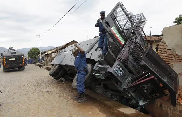 Riot police officers leave a water cannon vehicle after it crashed into a drain during protests against the Burundi's ruling CNDD-FDD descision to allow President Pierre Nkurunziza to run for a third five-year term in office in the capital Bujumbura, April 29, 2015. A top U.S. diplomat was heading to Burundi on Wednesday, seeking to halt escalating unrest triggered by President Pierre Nkurunziza's decision to seek a third term in office, a move protesters say is unconstitutional. (Photo by Thomas Mukoya/Reuters)