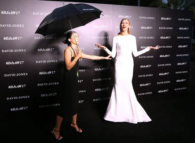 US model Karlie Kloss (R) reacts as she stands in heavy rain on the red carpet as she arrives to the dress rehearsal of the David Jones Autumn Winter 2017 collections launch in Sydney, Australia, 01 February 2017. (Photo by David Moir/AAP)