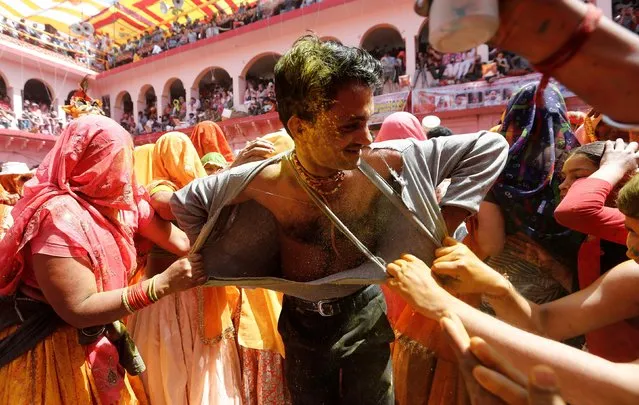 Women tear the shirt off a man during Huranga, a game played between men and women a day after Holi, at Dauji temple near the northern city of Mathura, India March 22, 2019. (Photo by Adnan Abidi/Reuters)
