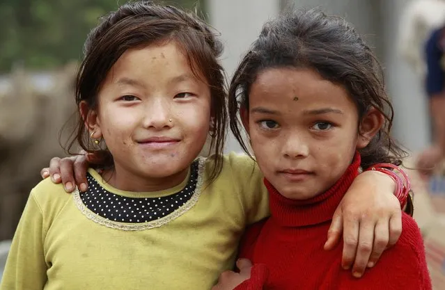 Pashmina Ghaley, 10, left, and her friend Ramina Bhujel, 10, pal around in the destroyed village of Balua, near the epicenter of Saturday's massive earthquake, in the Gorkha District of Nepal, Thursday, April 30, 2015. (Photo by Wally Santana/AP Photo)