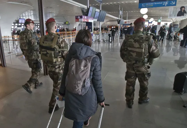 French soldiers patrol at Charles de Gaulle airport, in Roissy, north of Paris, Tuesday, March 22, 2016. Authorities are tightening security at airports and on the streets of European cities after attacks on the Brussels airport and subways system that killed at least one person and injured many others. Security has been beefed up in France, Austria, Poland and the Czech Republic. (Photo by Michel Euler/AP Photo)