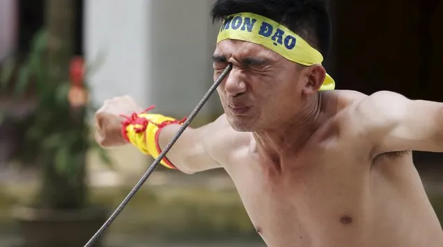 Vietnamese student Le Duc Thang, 24, bends a metal spear by pressing it into the area around his right eye as he performs during a showcase of traditional Thien Mon Dao kung fu at Du Xa Thuong village, southeast of Hanoi, Vietnam May 10, 2015. (Photo by Reuters/Kham)