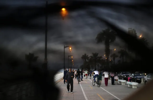 This Thursday, April 30, 2015 photo shows Lebanese citizens walking on the Corniche, or waterfront promenade in Beirut, Lebanon. (Photo by Hassan Ammar/AP Photo)