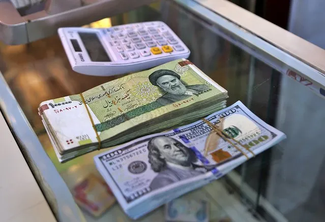 In this Wednesday, May 21, 2019, photo, U.S. and Iranian currency are readied by a money exchanger outside the golden-domed shrine of Imam Moussa al-Kadhim in Kadhimiya district in north Baghdad, Iraq. (Photo by Khalid Mohammed/AP Photo)
