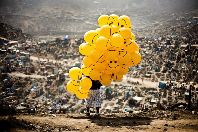 “A man sells balloons in a cemetery in Lima to cheer up families who are there to remember their dead”. (Photo and caption by Milko Torres Ramirez/2014 Sony World Photography Awards)