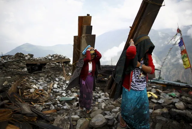 Earthquake victims carry wood recovered from a collapsed house at Barpak village at the epicenter of the April 25 earthquake in Gorkha district, Nepal, May 21, 2015. (Photo by Navesh Chitrakar/Reuters)