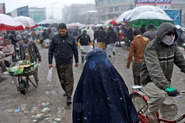 An Afghan woman walks on the street during a snowfall in Kabul, Afghanistan, January 3, 2022. (Photo by Ali Khara/Reuters)