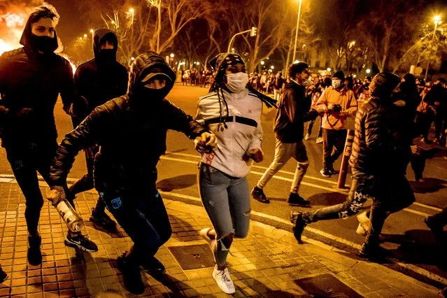People clash with riot police during a demonstration against the imprisonment of rapper Pablo Hasel, in Barcelona, Spain, on February 19, 2021. Violent street protests over the imprisonment of a rapper have erupted for a fourth straight night in Spain. (Photo by Albert Llop/NurPhoto/Rex Features/Shutterstock)