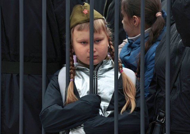 A girl stands behind a barrier during a parade on Victory Day, which marks the 79th anniversary of the victory over Nazi Germany in World War Two, in Vladivostok, Russia, on May 9, 2024. (Photo by Tatiana Meel/Reuters)