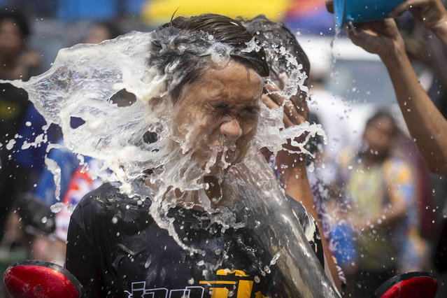 A man reacts as water is splashed on him during the Songkran water festival to celebrate the Thai New Year in Prachinburi Province, Saturday April 13, 2024. It's the time of year when many Southeast Asian countries hold nationwide water festivals to beat the seasonal heat, as celebrants splash friends, family and strangers alike in often raucous celebration to mark the traditional Theravada Buddhist New Year. (Photo by Wason Wanichakorn/AP Photo)