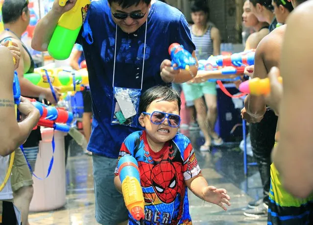 Foreign tourists join the annual Songkran Festival celebration, the Thai traditional New Year, also known as the water festival in Silom district of Bangkok, Thailand, 13 April 2014. The three-day Songkran Festival runs from 13 to 15 April and is celebrated with splashing water and putting powder on each others faces as a symbolic sign of cleansing and washing away the sins from the old year. (Photo by Narong Sangnak/EPA)