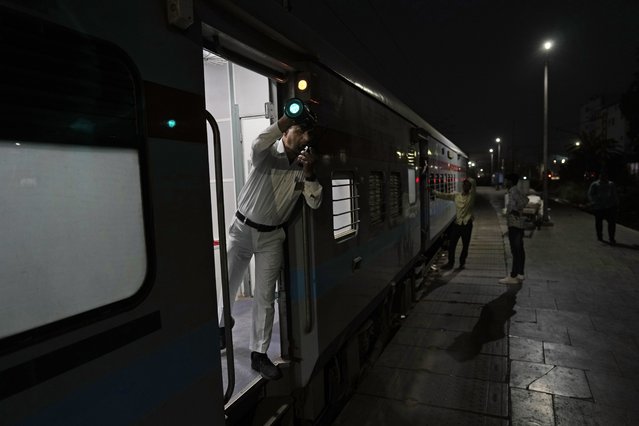 A railway guard shows the signal for the train to start, on board the Thirukkural Express at Nizamuddin railway station in New Delhi, Saturday, April 20, 2024. The Thirukkural Express stretches from New Delhi, the heart of India, to Kanyakumari, India's southernmost tip. (Photo by Manish Swarup/AP Photo)