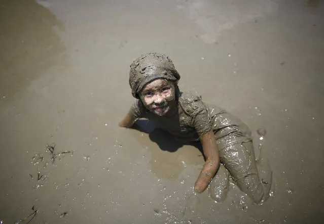 A girl plays on the mud during the Asar Pandhra festival in Pokhara valley, west of Nepal's capital Kathmandu, June 30, 2015. (Photo by Navesh Chitrakar/Reuters)