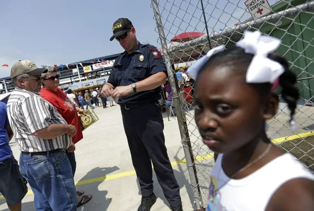 A guard takes tickets as people enter the Angola Prison Rodeo in Angola, La., Saturday, April 26, 2014. In a half-century, the event has grown from a small event for prisoners into a big business that draws thousands of spectators to the Louisiana State Penitentiary. (Photo by Gerald Herbert/AP Photo)