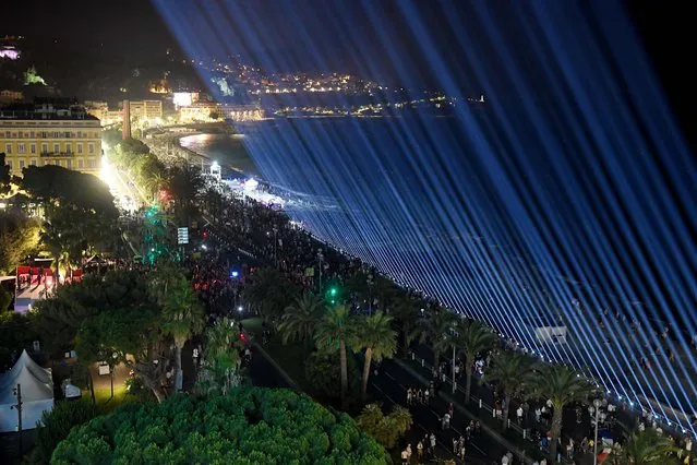 Eighty-six lights are displayed at night over the Promenade des Anglais in Nice, southeastern France, on July 14, 2021, to mark the 5th anniversary of a jihadist truck attack. A man drove a truck 6 years ago into a crowd, killing 86 people, in an attack claimed by the Islamic State group at a Bastille Day fireworks display. (Photo by Nicolas Tucat/AFP Photo)