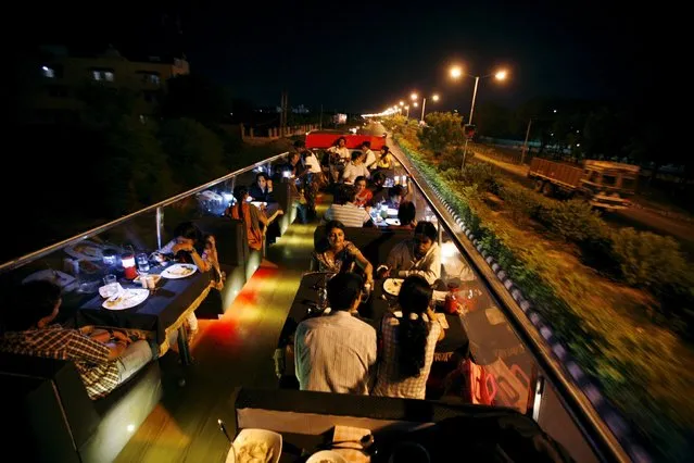 People dine on a double-decker bus which has been converted to a mobile restaurant as it travels through the streets of the western Indian city of Ahmedabad June 23, 2010. (Photo by Amit Dave/Reuters)