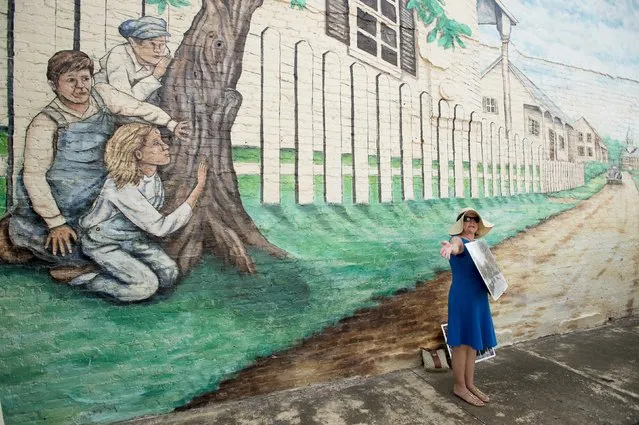 Sandy Smith stands in front of a mural of a scene from “To Kill a Mockingbird” while leading a walking tour in Monroeville, Alabama July 14, 2015. The southern hometown of author Harper Lee is celebrating the release of “Go Set a Watchman”, Lee's first published novel in 55 years. (Photo by Michael Spooneybarger/Reuters)