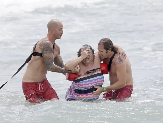 Fort Lauderdale Ocean Rescue lifeguards John Trujillo, left, and Tom Frezza, right, help Gina Rebelo, center, of Toronto, Canada, to shore after she was caught up in a rip current, Tuesday, May 13, 2014 in Fort Lauderdale, Fla. South Florida beachgoers are being warned to be careful in the ocean after a rip current advisory was extended. (Photo by AP Photo)