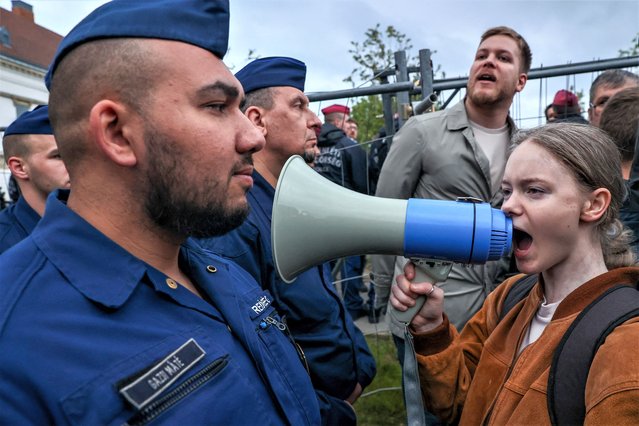 A student uses a loudspeaker next to a police line during a demonstration in front of  Hungary's Prime Minister's office in the Castle District in Budapest on April 24, 2023. Clashes between the police and several hundred student protesters occured in the Castle District in Budapest, following the latest in a series of attempts by opposition lawmakers to dismantle the cordon barriers that bar entry to the area. (Photo by Istvan Huszti/AFP Photo)