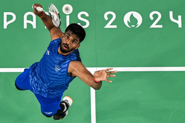 India's Satwiksairaj Rankireddy hits a shot in his men's doubles badminton group stage match against France during the Paris 2024 Olympic Games at Porte de la Chapelle Arena in Paris on July 27, 2024. (Photo by Sebastien Berda/AFP Photo)