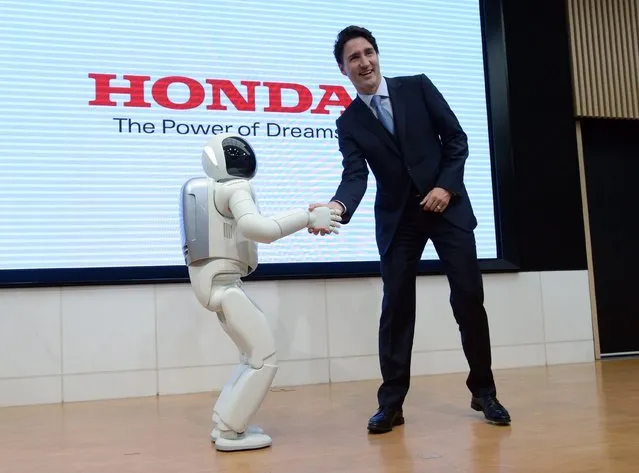 Canadian Prime Minister Justin Trudeau meets Honda Robot Asimo as he visits Honda Motor Co. headquarters in Tokyo, Japan, on Tuesday, May 24, 2016. (Photo by Sean Kilpatrick/The Canadian Press via AP Photo)