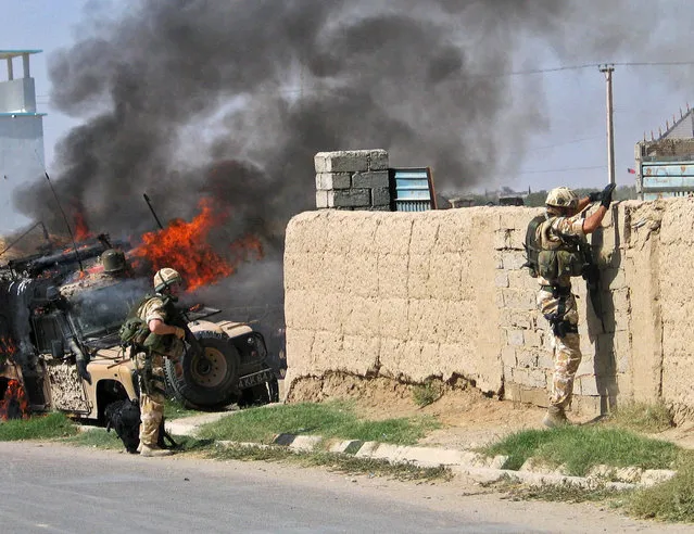 British soldiers with the NATO force try to secure the site of a suicide attack in Afghanistan's southern Helmand province October 19, 2006. Several Afghans and two NATO soldiers were killed when a suicide bomber threw himself at the troops in southern Afghanistan, witnesses and an army officer said. (Photo by Abdul Qodous/Reuters)