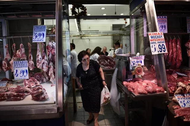 An elderly woman shops meat at Varvakios market in Athens, Saturday, July 25, 2015. Greece on Friday invited the International Monetary Fund to participate in its negotiations with European creditors over a vital third bailout. The talks are expected to start next week after a few days' delay and must conclude before Greece faces another big repayment August 20. (Photo by Giannis Papanikos/AP Photo)