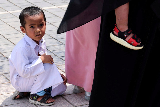 A child sits on the ground at Imam Muhammad ibn Abd al-Wahhab Mosque after Friday prayers and funeral prayers for assassinated Hamas chief Ismail Haniyeh were held on the day of Haniyeh's burial, in Doha, Qatar, on August 2, 2024. (Photo by Saleh Salem/Reuters)