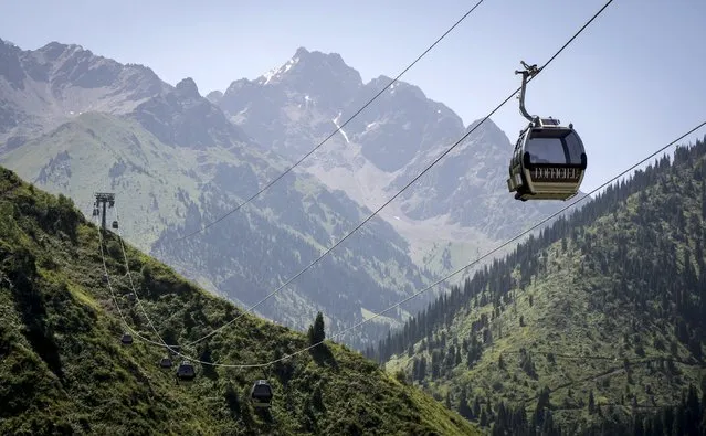 Cable cars are pictured against the backdrop of the Tien Shan mountains near the Medeu skating oval in Almaty, Kazakhstan, July 26, 2015. (Photo by Shamil Zhumatov/Reuters)