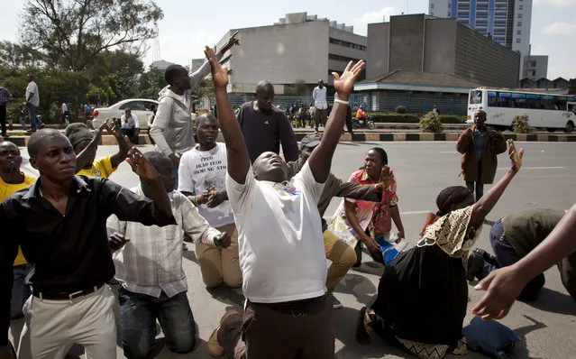 Demonstrators kneel down and shout that they are peaceful, outside the electoral commission offices, in downtown Nairobi, Kenya Monday, June 6, 2016. (Photo by Ben Curtis/AP Photo)