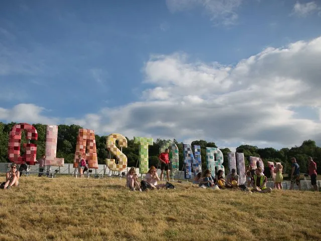 People gather below the Glastonbury sign at Worthy Farm in Pilton on the eve of the first day of the 2014 Glastonbury Festival. (Photo by Ian Gavan/Getty Images)