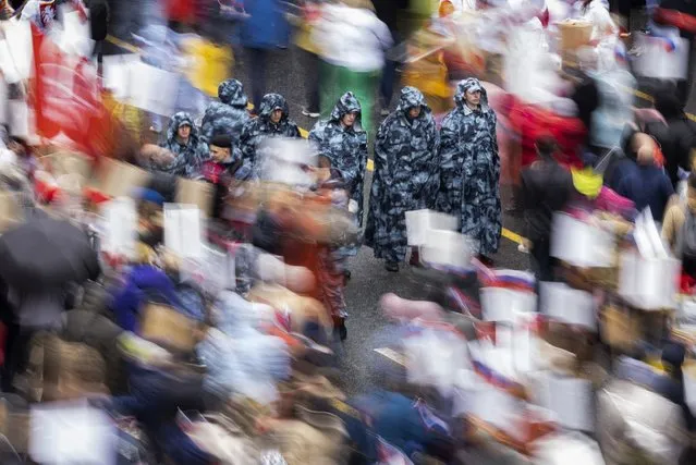 Russian police officers patrol as people attend the Immortal Regiment march through the main street toward Red Square marking the 77th anniversary of the end of World War II, in Moscow, Russia, Monday, May 9, 2022. (Photo by Denis Tyrin/AP Photo)