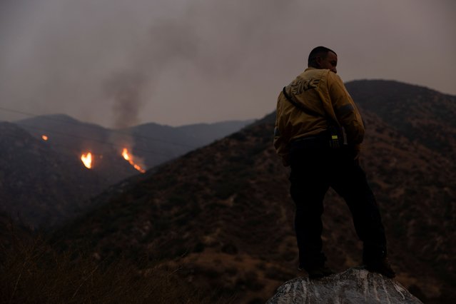 A firefighter monitors the progression of the Line Fire in the San Bernardino National Forest’s mountains over Highland, California on September 8, 2024. (Photo by Etienne Laurent/Reuters)