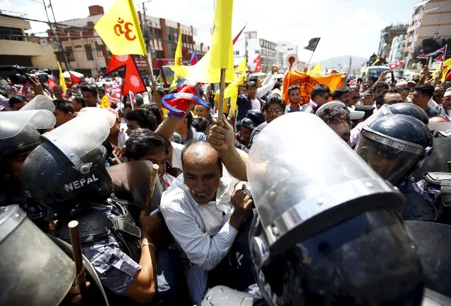 Hindu activists chant slogans as they try to break through the restricted area during the protest rally marching towards the parliament demanding Nepal to be declared as Hindu State in the new constitution, in Kathmandu August 3, 2015. (Photo by Navesh Chitrakar/Reuters)