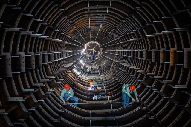 Employees work on a steel tube tower production line at a factory in Haian, in eastern China's Jiangsu province on September 1, 2024. (Photo by AFP Photo/China Stringer Network)