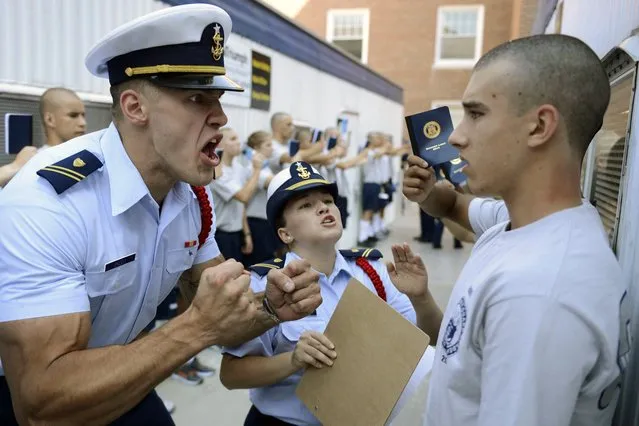 United States Coast Guard Academy Cadets Second Class Aurimas Juodka, left, and Sheila Bertrand get in the face of “swab” Kevin Lennox as Bravo Company finishes at the barber shop and mailroom during R-Day, the reporting-in day that marks the beginning of the 7-week “Swab Summer” for the class of 2018 Monday, June 30, 2014, in New London, Conn. (Photo by Sean D. Elliot/AP Photo/The Day)